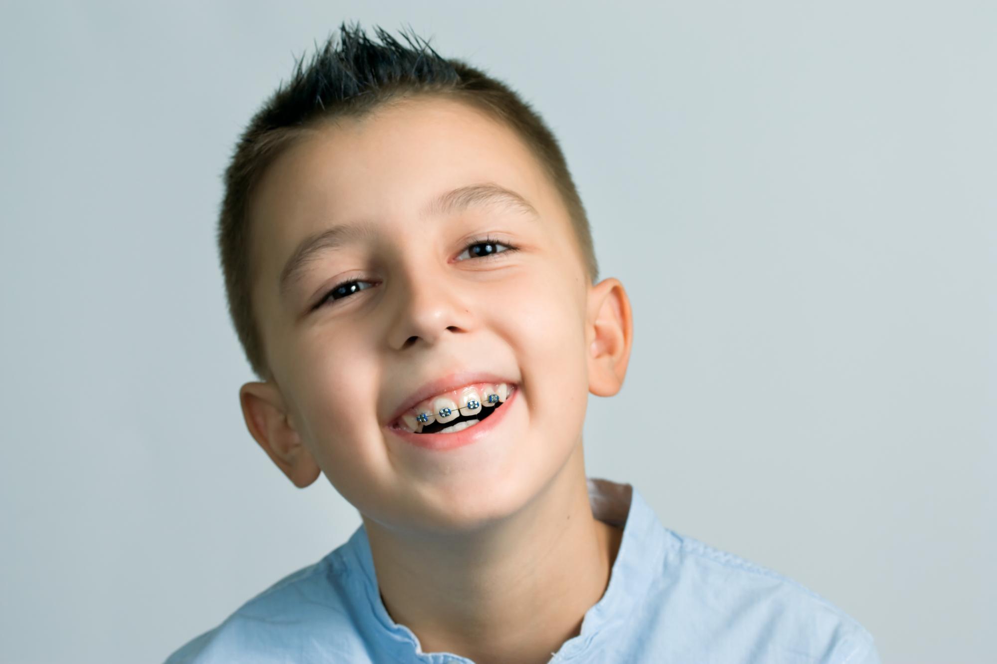 Smiling child with colorful metal braces at Premier Orthodontics